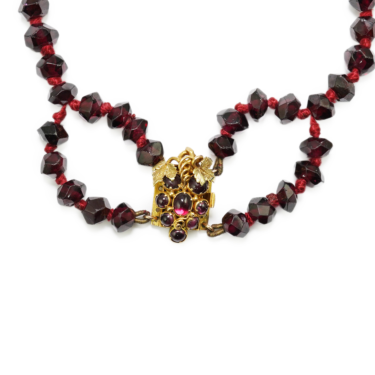 A Victorian facet cut garnet necklace, with cabochon garnet cluster set gold clasp